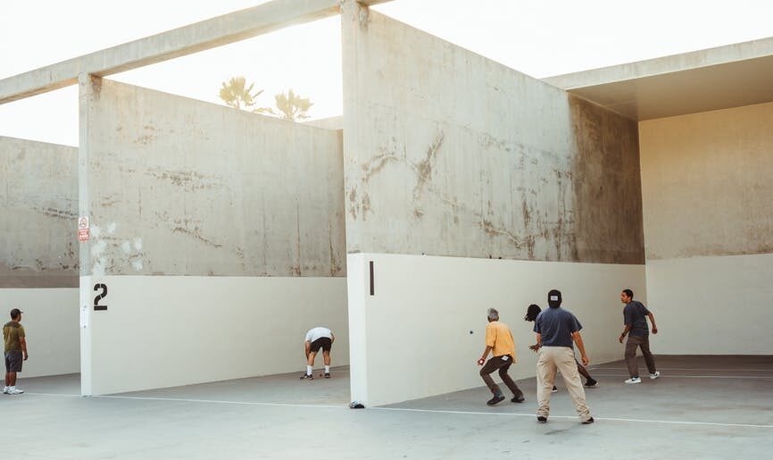 anonymous athletes playing handball in outdoor courts in sunlight